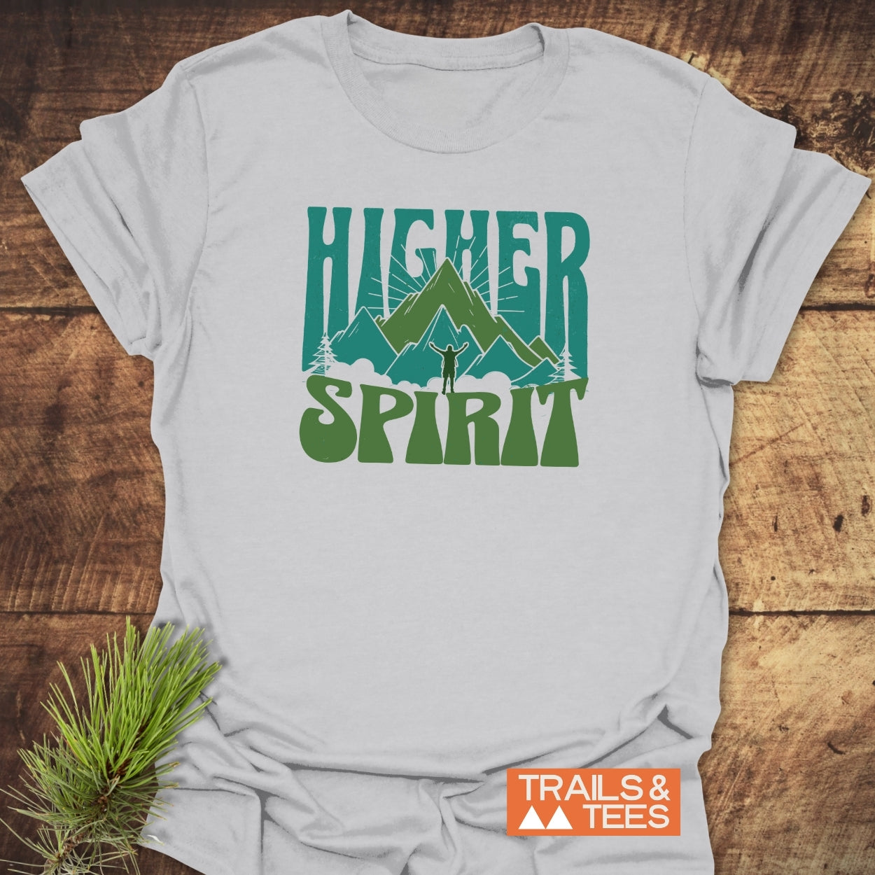 Higher Spirit T-Shirt featuring a stylized mountain scene with a raised arms silhouette, crafted from soft cotton for everyday outdoor adventures.