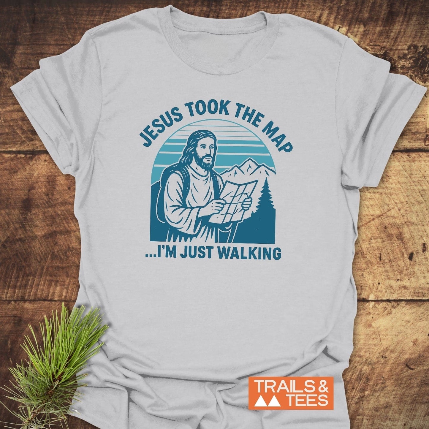 Jesus Took The Map T-Shirt featuring Jesus with a backpack and map in a mountain scene, emphasizing adventure-ready comfort and durable, eco-friendly design.