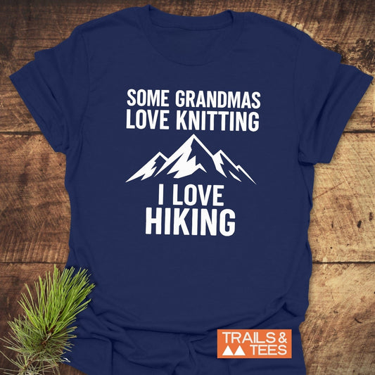 Navy-blue Hiking Grandma Funny T-Shirt with Some Grandmas Love Knitting, I Love Hiking text and mountain graphic, featuring a small TRAILS & TEES. logo.