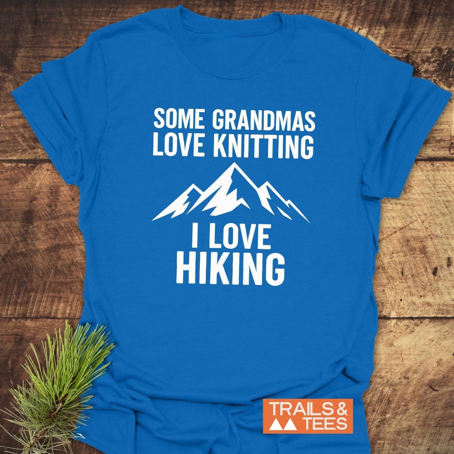 Hiking Grandma Funny T-Shirt in bright blue with mountain graphic and text. Soft cotton, durable print, pre-shrunk, taped shoulders, promoting outdoor love.