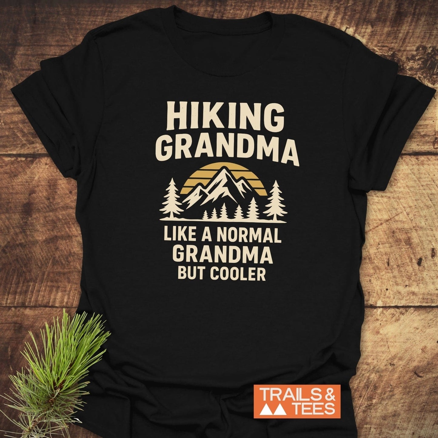 Hiking Grandma Sunrise T-Shirt featuring a sunset mountain graphic with pine trees, crafted from soft cotton, offering a comfortable fit and durable design.