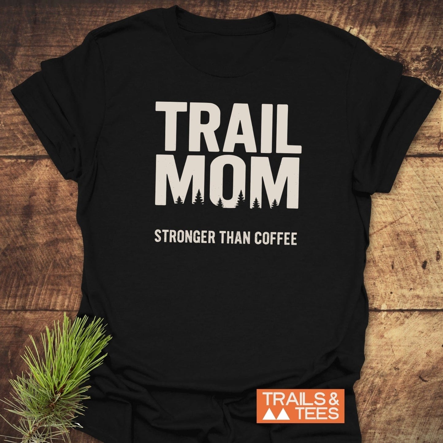 Black Mom Stronger Than Coffee T-Shirt with evergreen tree silhouettes. Features durable prints, ring-spun cotton, taped shoulders, and no side seams for comfort.