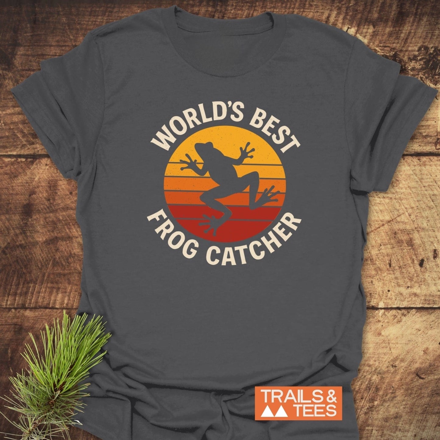 Frog Catcher T-Shirt featuring a retro sunset graphic and leaping frog, perfect for outdoor enthusiasts. Soft, durable, and pre-shrunk for a perfect fit.