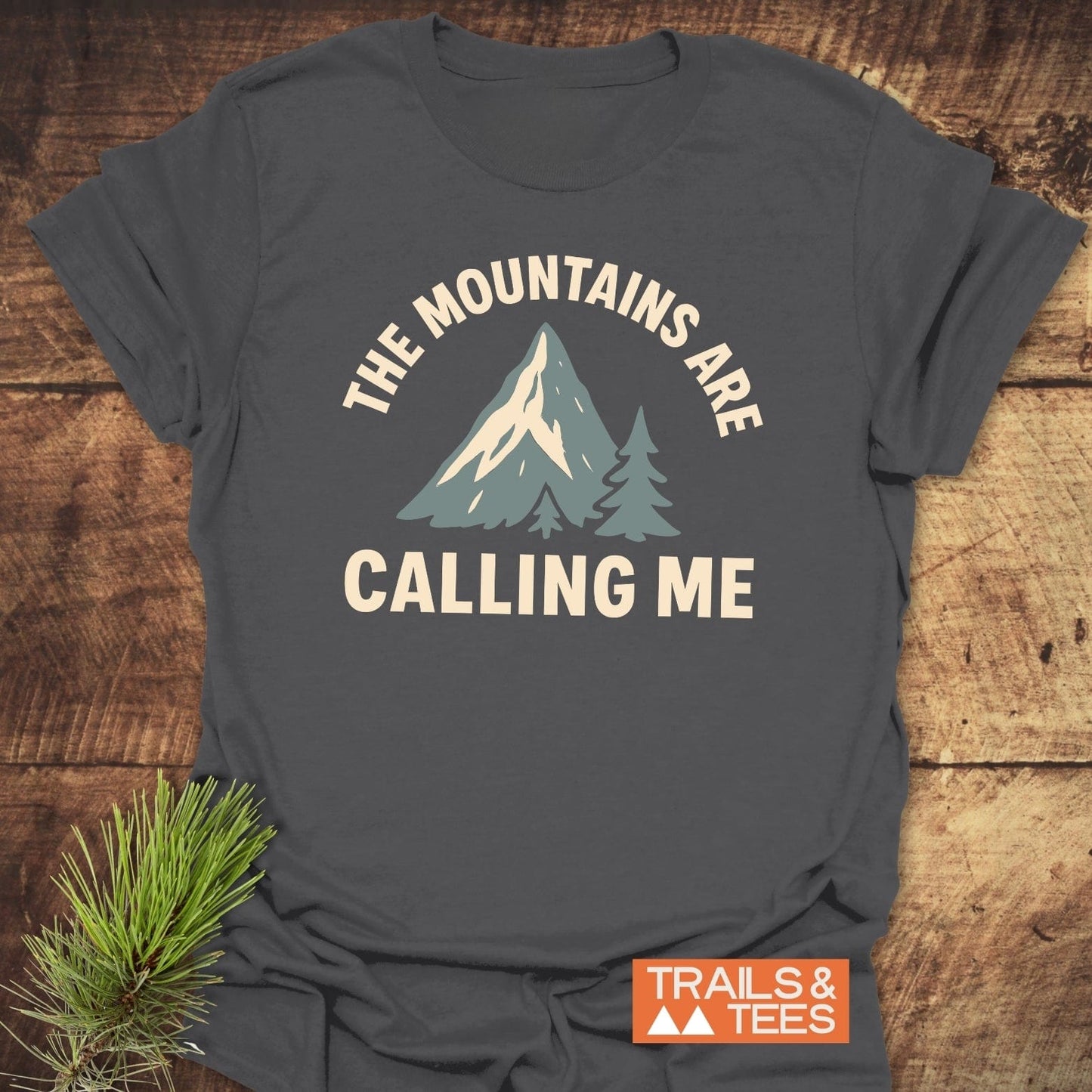 Mountains Calling Me T-Shirt with mountain graphic and slogan, crafted from soft cotton for comfort. Pre-shrunk, durable print, designed for outdoor enthusiasts.