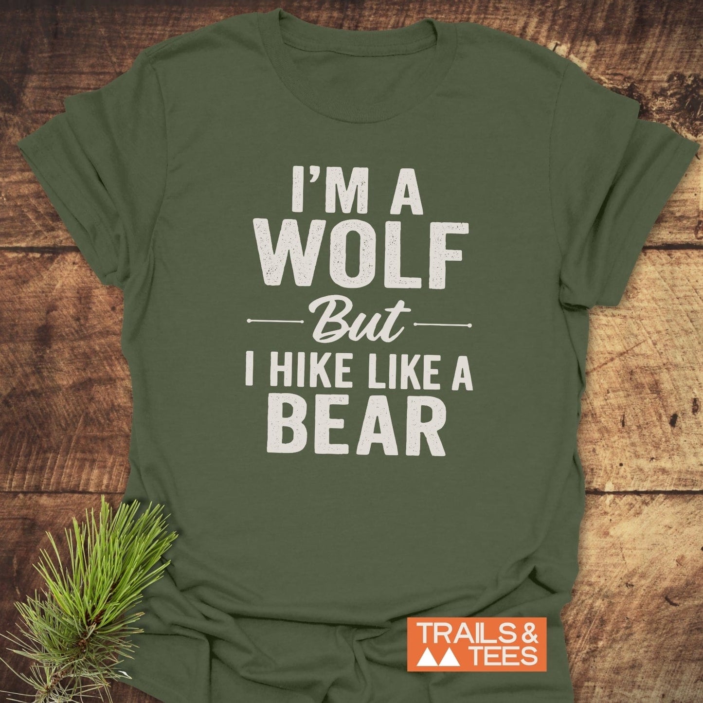 I'm A Wolf Funny T-Shirt on wooden surface, featuring a bear hiking slogan in white, with 'TRAILS & TEES' logo, embodying outdoor adventure spirit.