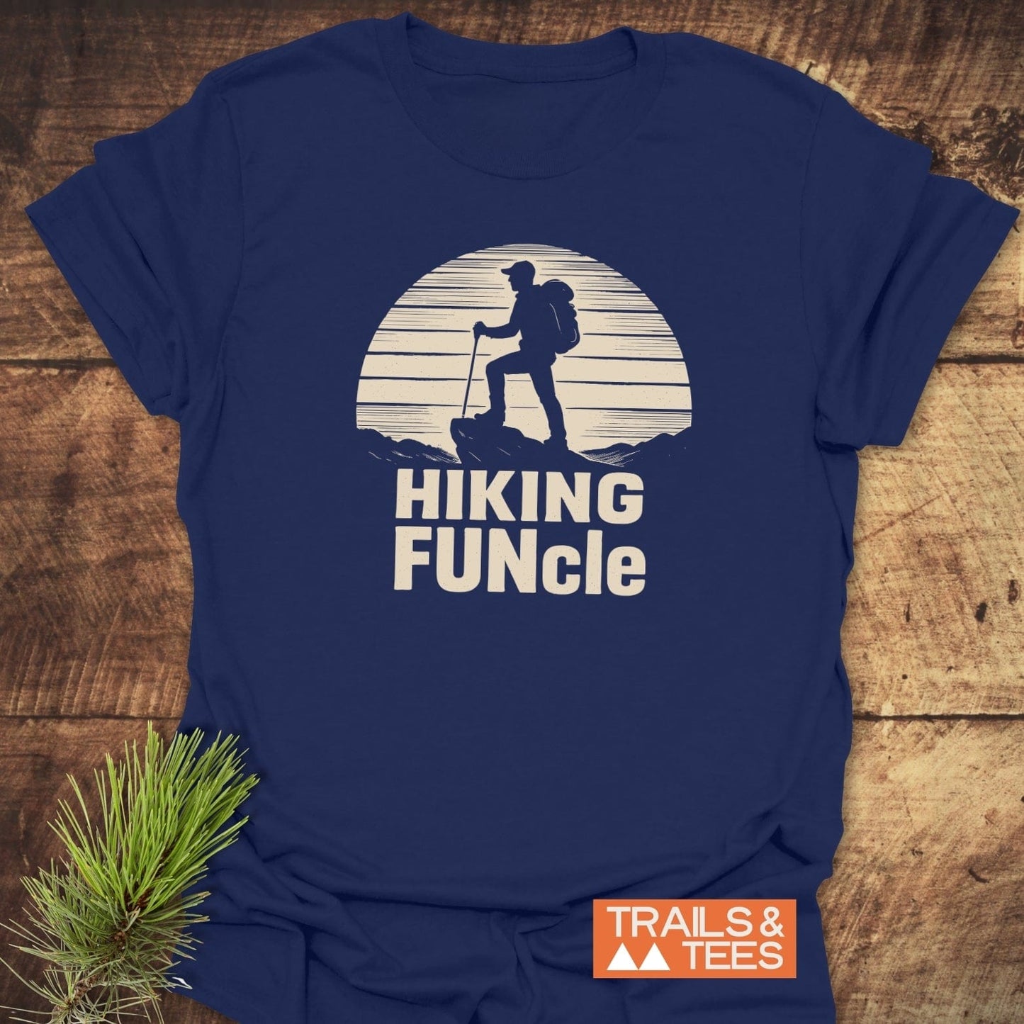 Navy-blue Hiking FUNcle T-Shirt with a hiker graphic and slogan, laid on wood. Features durable prints and soft cotton for outdoor enthusiasts.