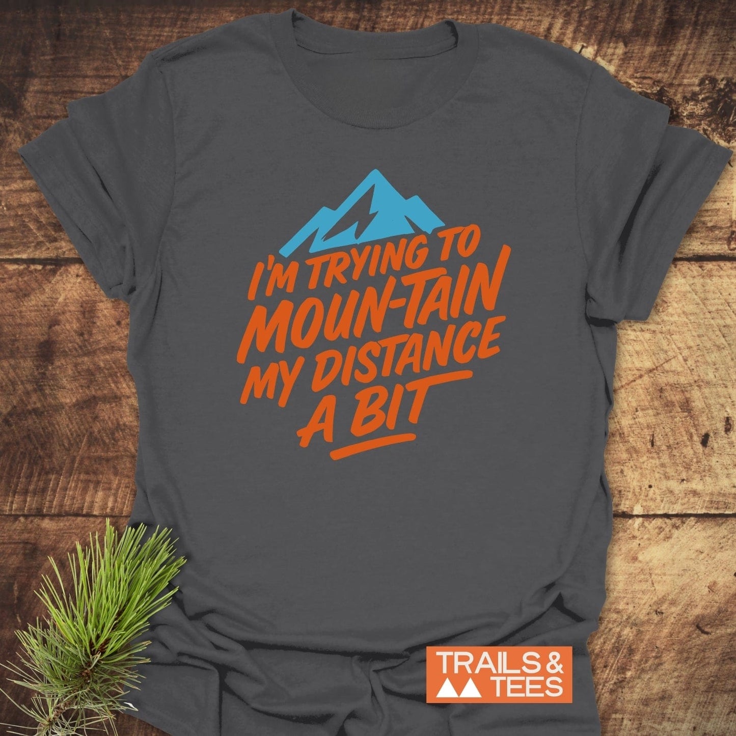 Charcoal-gray Moun-Tain Distance Funny T-Shirt with mountain graphic and slogan. Soft, ring-spun cotton, pre-shrunk, durable print, outdoor-themed.