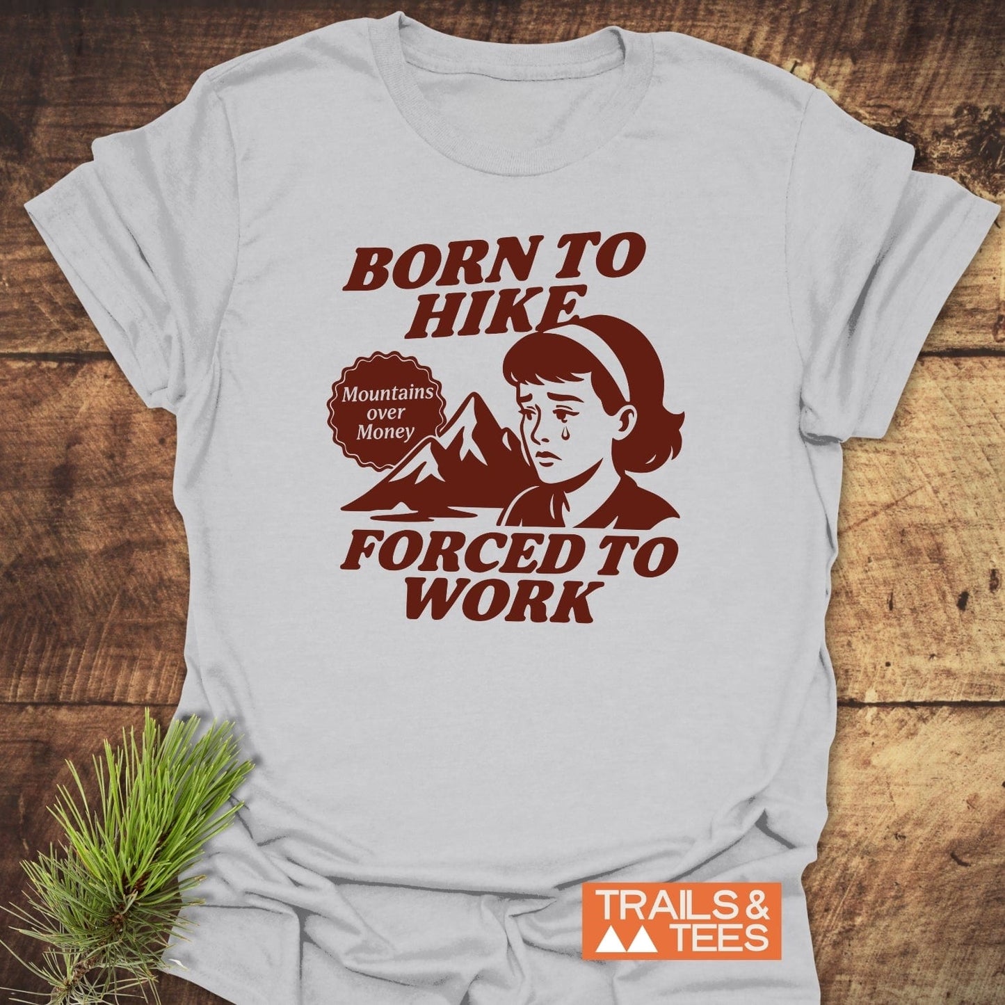 Born To Hike T-Shirt with retro character, mountain illustration, and slogan on soft cotton; durable print, no side seams, pre-shrunk for reliable fit.