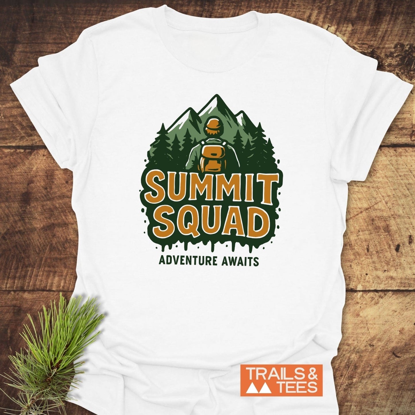 Summit Squad Hiking T-Shirt: White tee with hiker and mountain graphic, SUMMIT SQUAD text, and TRAILS & TEES branding, celebrating outdoor adventures.