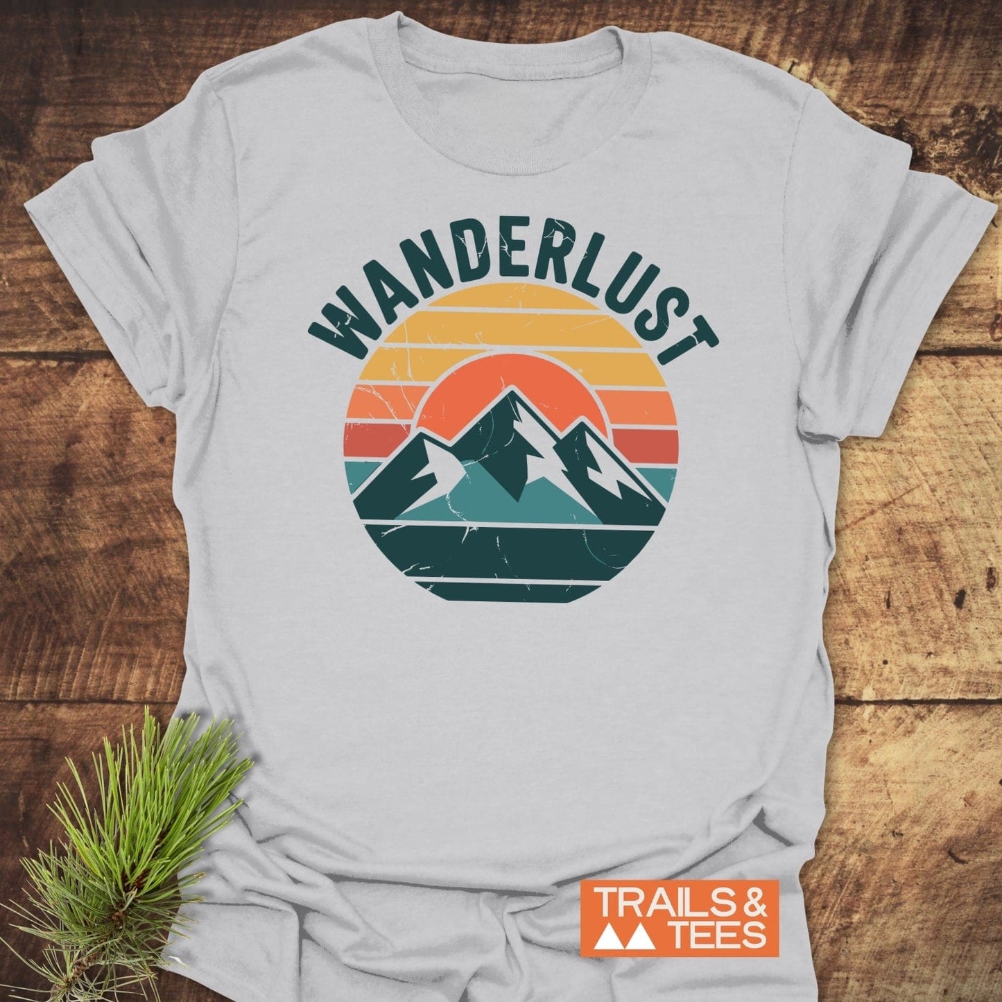 Wanderlust T-Shirt featuring a retro mountain graphic and WANDERLUST text, crafted from soft cotton for comfort, durability, and outdoor adventures.
