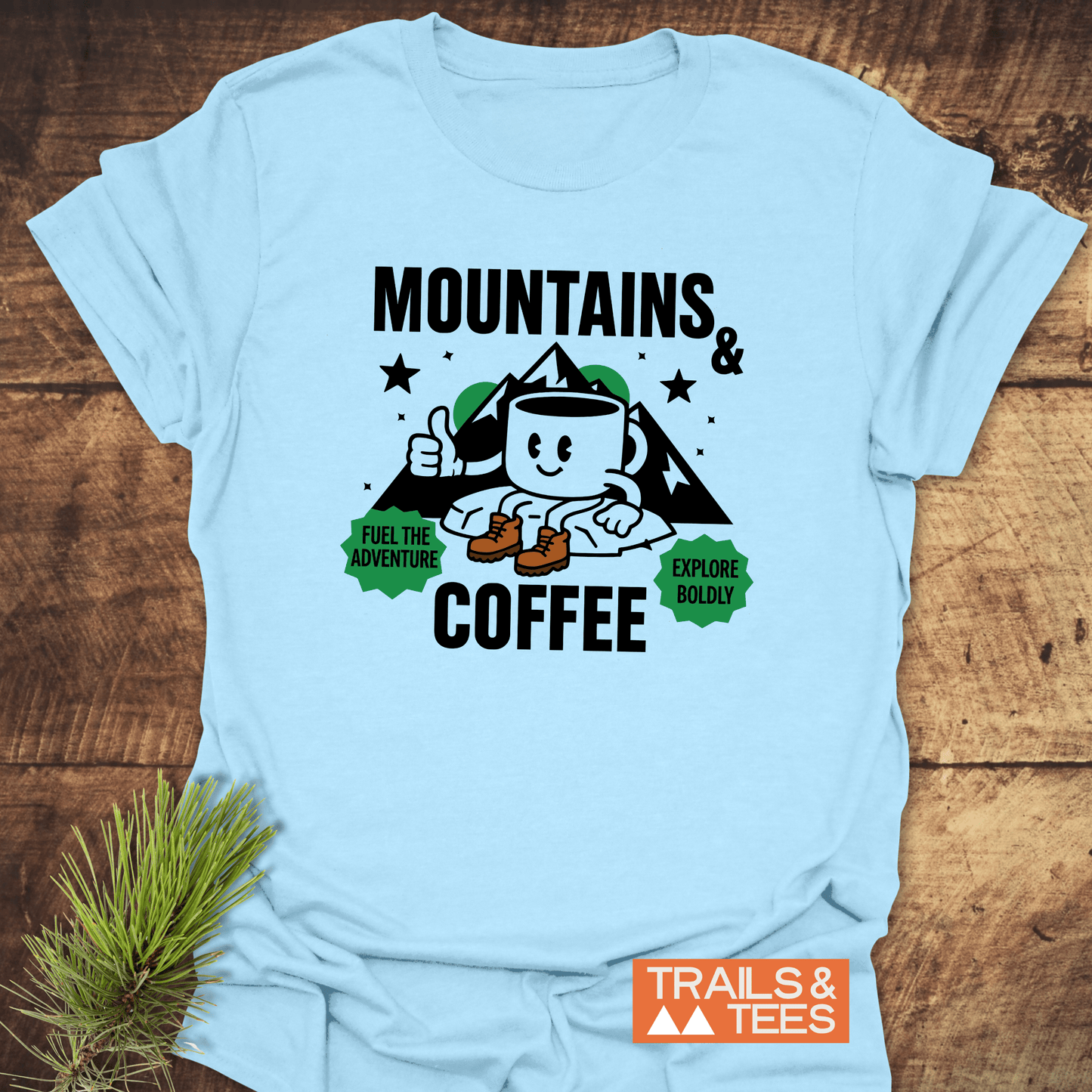 Mountains & Coffee Retro T-Shirt with a hiking mug graphic, mountain backdrop, adventure badges, and TRAILS & TEES logo, crafted for comfort and durability.