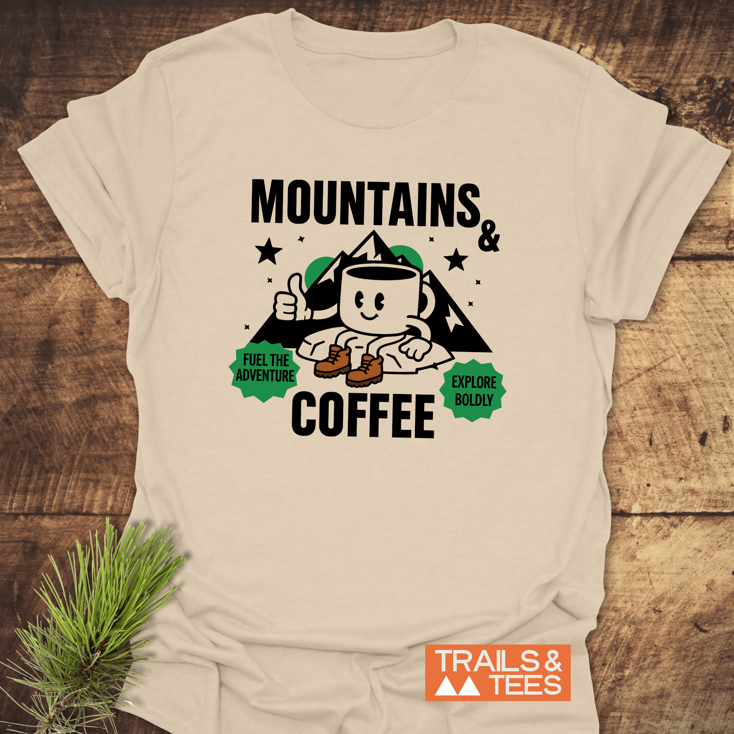 Mountains & Coffee Retro T-Shirt featuring a cartoon coffee mug in boots, mountain peaks, and motivational badges, perfect for outdoor adventure enthusiasts.