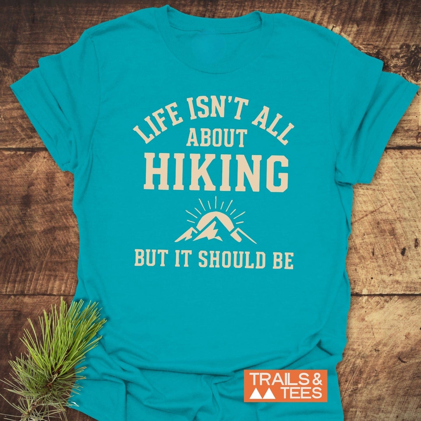Life Isn't All About Hiking T-Shirt with mountain graphic and slogan, featuring durable, lightweight cotton, pre-shrunk fit, and Trails & Tees logo.
