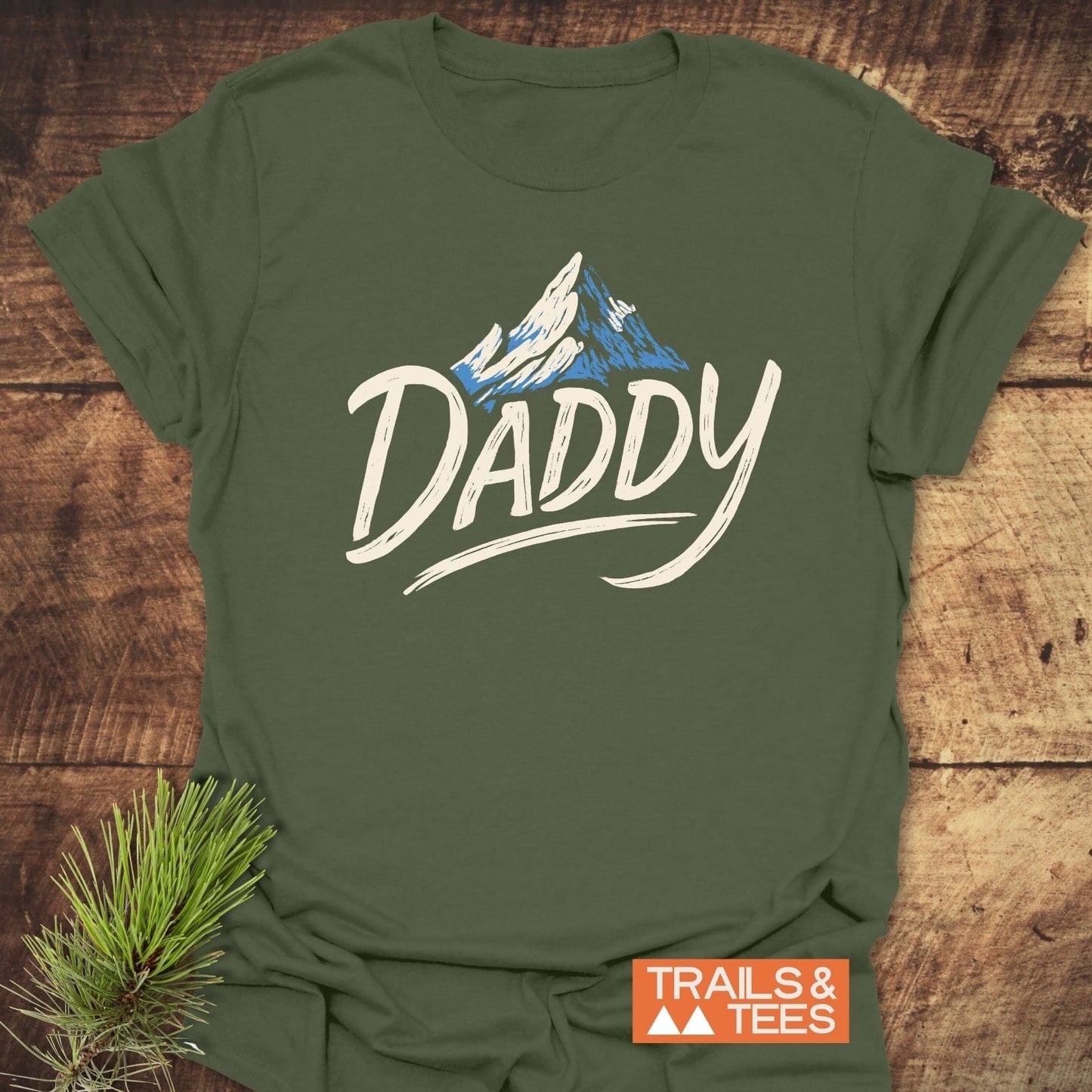 Mountain Daddy T-Shirt with snowy mountain graphic, featuring durable prints on soft, ring-spun cotton. Ideal for outdoor enthusiasts, promoting comfort and adventure.