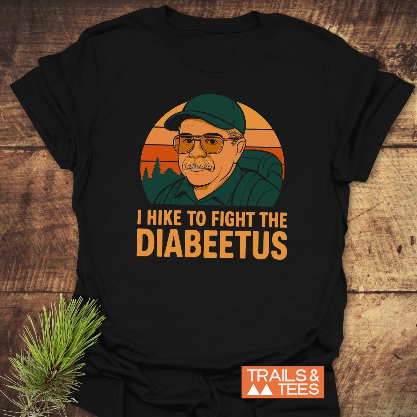 Retro Diabeetus Funny T-Shirt featuring an older man’s portrait against an orange sunset, highlighting “I HIKE TO FIGHT THE DIABEETUS” with Trails & Tees logo.