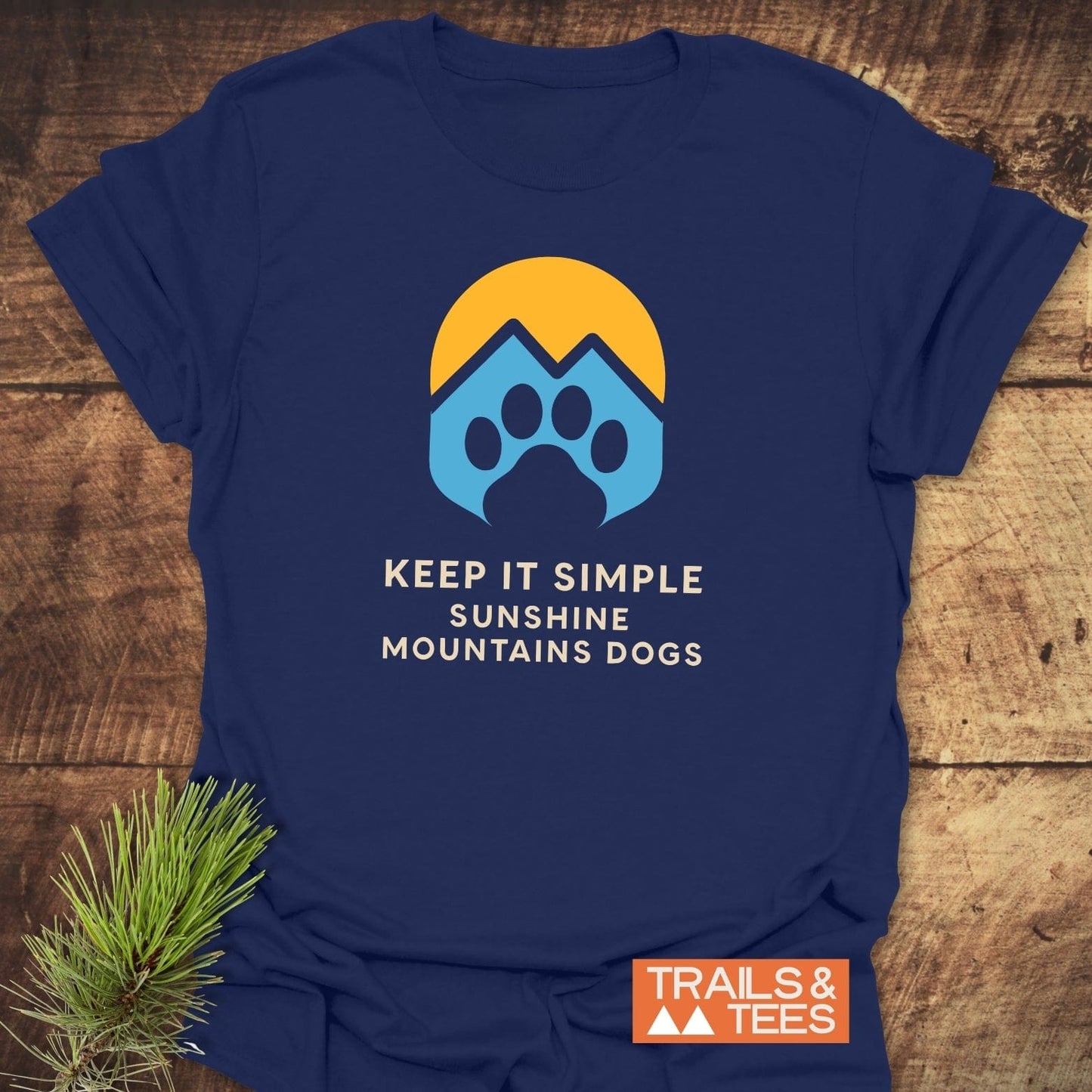 Navy-blue Sun Mountains Dogs T-Shirt with a golden sun, mountain, and paw print graphic, featuring the slogan KEEP IT SIMPLE — SUNSHINE MOUNTAINS DOGS.