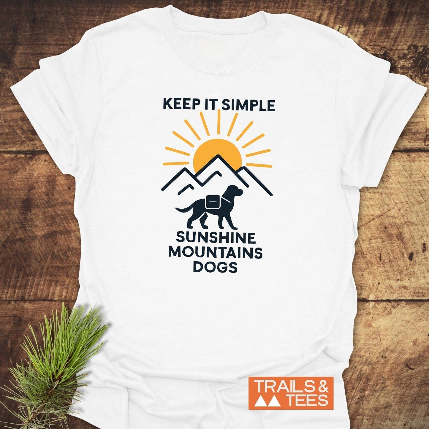 Minimalist Hiking Dog T-Shirt featuring a sun and mountains graphic with a pack-wearing dog, emphasizing trail-ready comfort and eco-friendly, durable design.