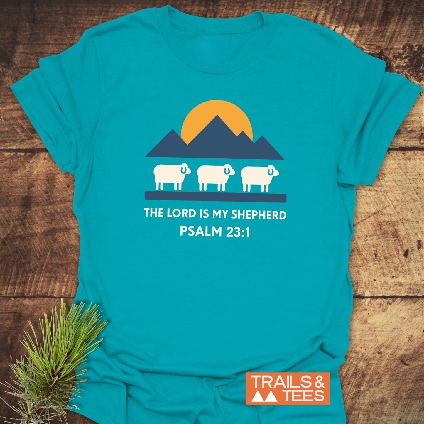 The Lord Is My Shepherd T-Shirt with a sheep and mountain graphic, Psalm 23:1 text, crafted for comfort in lightweight cotton, ideal for outdoor enthusiasts.