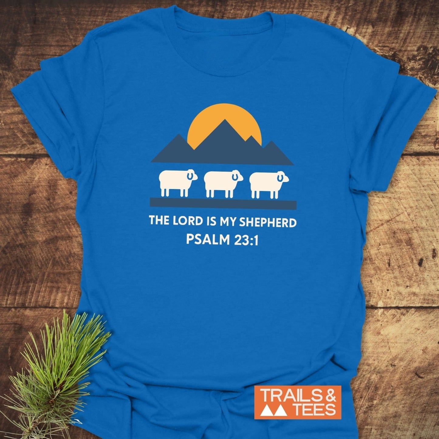 The Lord Is My Shepherd T-Shirt featuring three sheep and mountains, crafted from soft cotton for comfort. Includes durable print and brand logo, perfect for outdoor enthusiasts.