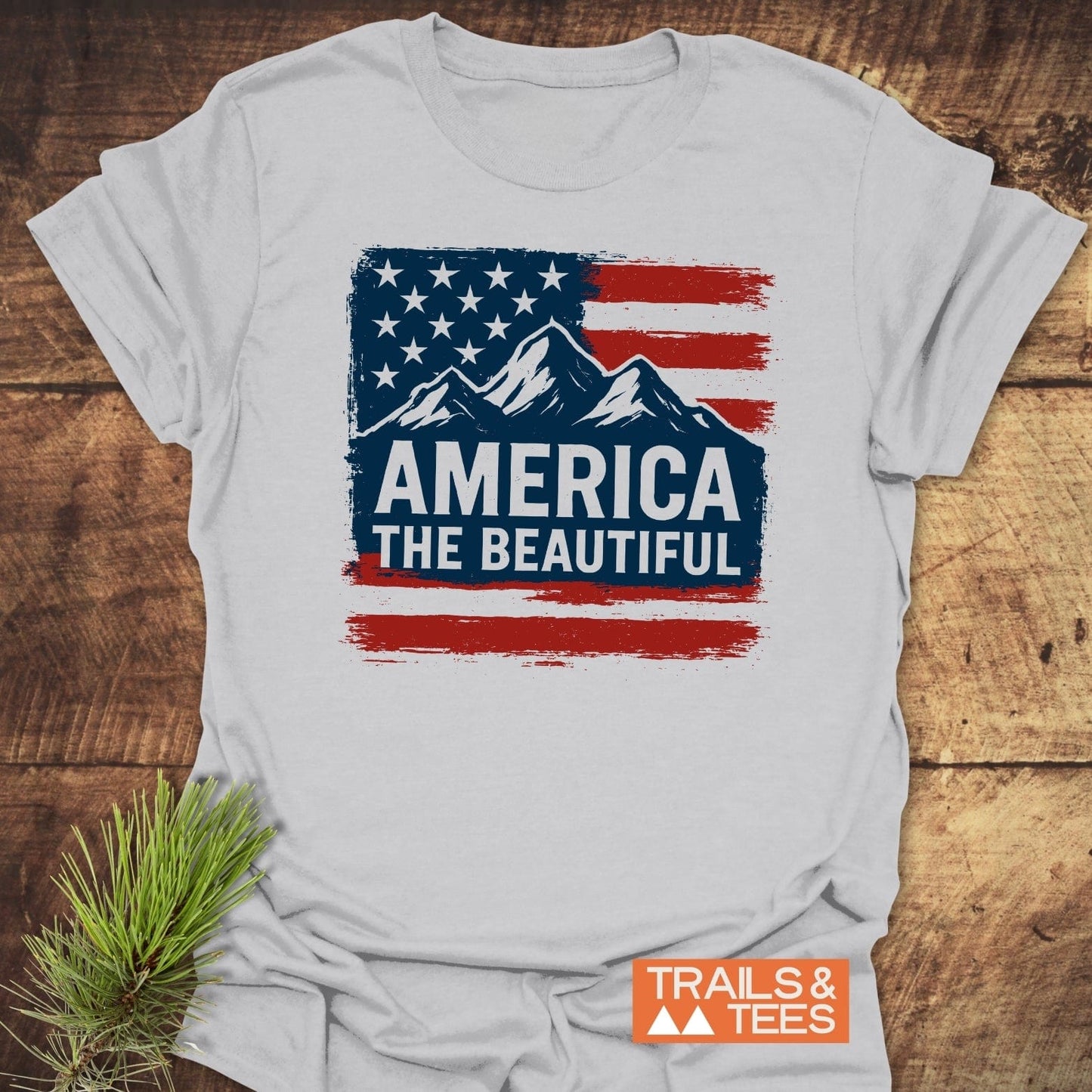 America The Beautiful T-Shirt featuring a distressed U.S. flag and mountain graphic, highlighting outdoor spirit, made from soft ring-spun cotton, perfect for adventures.