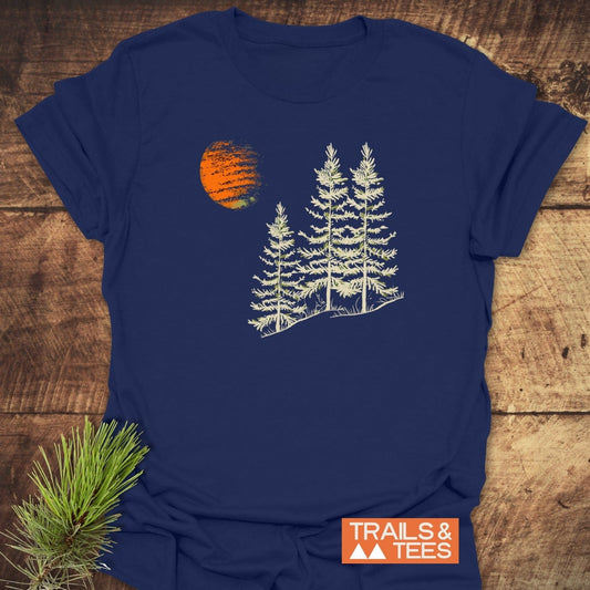Forest And Moon T-Shirt: Navy blue tee with a graphic of three pine trees and an orange sun, showcasing outdoor-inspired design.