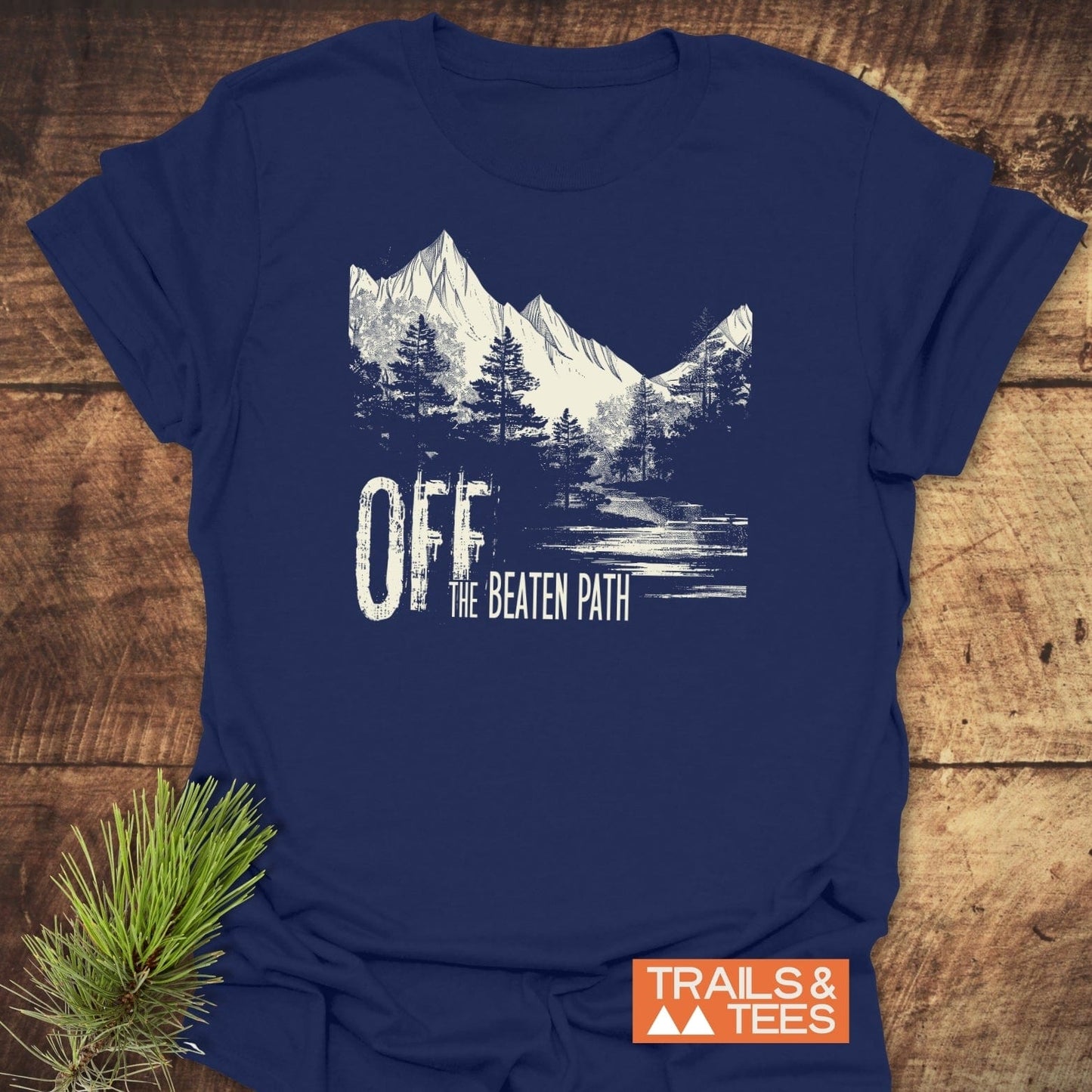 Off The Beaten Path T-Shirt featuring a mountain and pine graphic. Crafted from soft cotton, it's pre-shrunk and durable, perfect for outdoor enthusiasts.