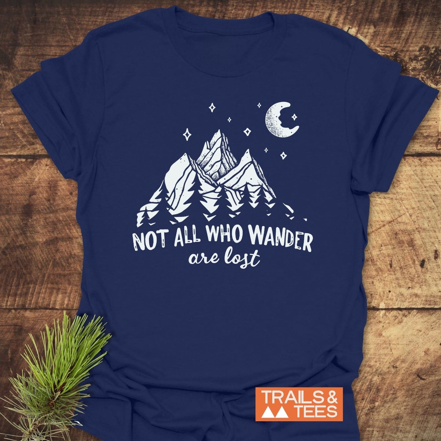 Navy-blue Not All Who Wander T-shirt featuring a mountain scene with trees, stars, and moon, emphasizing outdoor adventure, made from soft, durable ring-spun cotton.