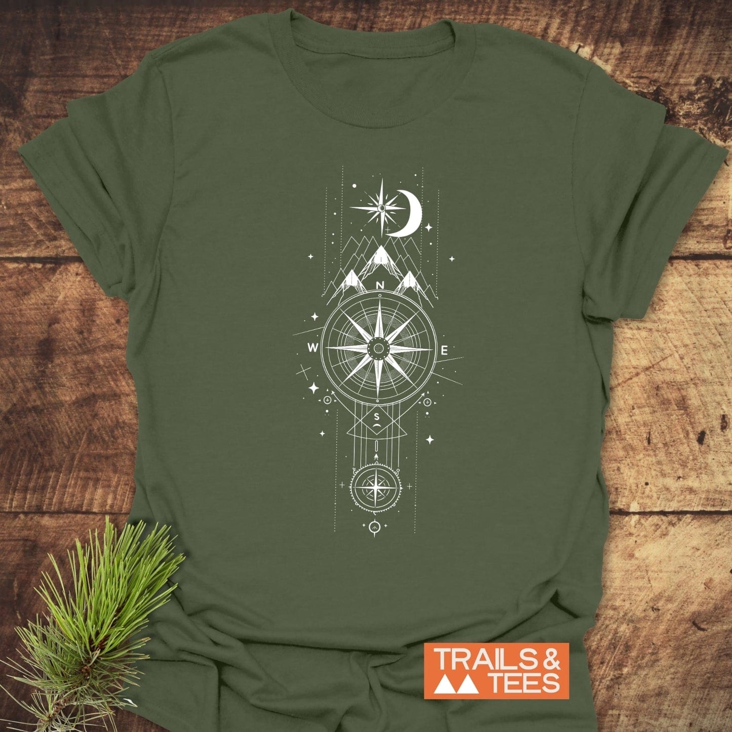 Celestial Compass T-Shirt featuring a compass rose, mountains, and stars, printed on soft, ring-spun cotton for comfort, durability, and adventure-ready style.