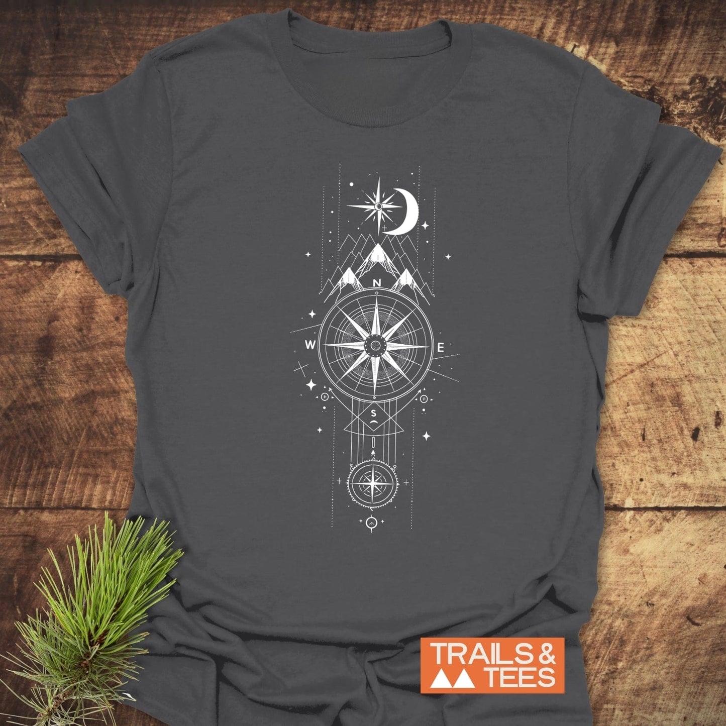 Celestial Compass T-Shirt features a white compass, mountain, moon, and star graphic on dark-gray fabric, highlighting outdoor adventure.