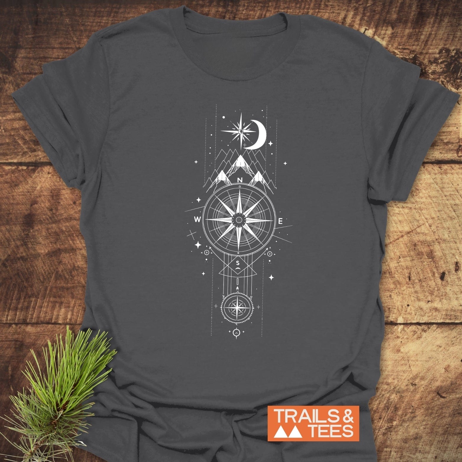 Celestial Compass T-Shirt features a white compass, mountain, moon, and star graphic on dark-gray fabric, highlighting outdoor adventure.