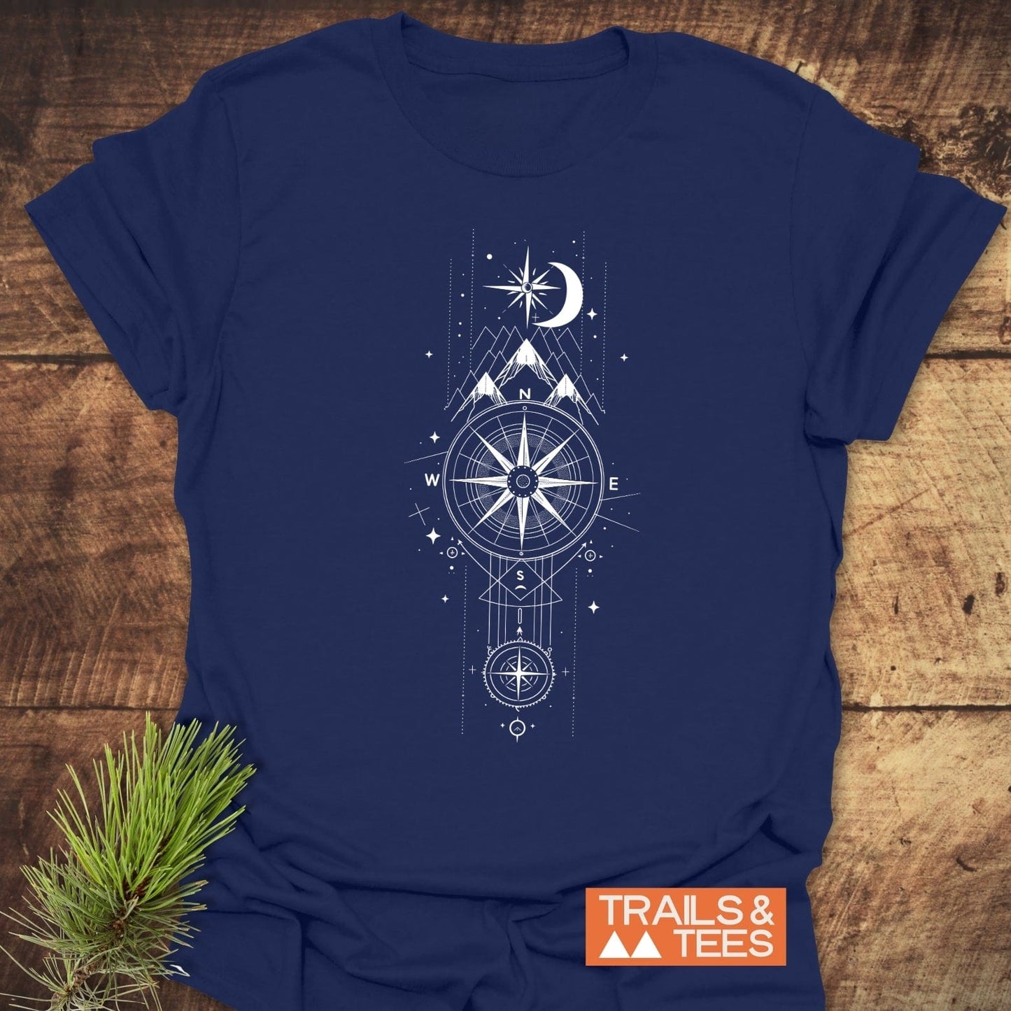 Celestial Compass T-Shirt: Navy tee with compass, mountains, moon, and stars design. Lightweight, ring-spun cotton for comfort. Features durable prints and eco-friendly production.