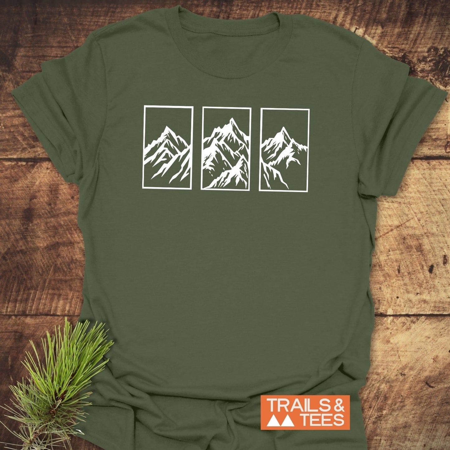 Mountain Triptych T-Shirt featuring white mountain line-art on olive-green fabric, with TRAILS & TEES logo, crafted from soft, ring-spun cotton for everyday adventures.