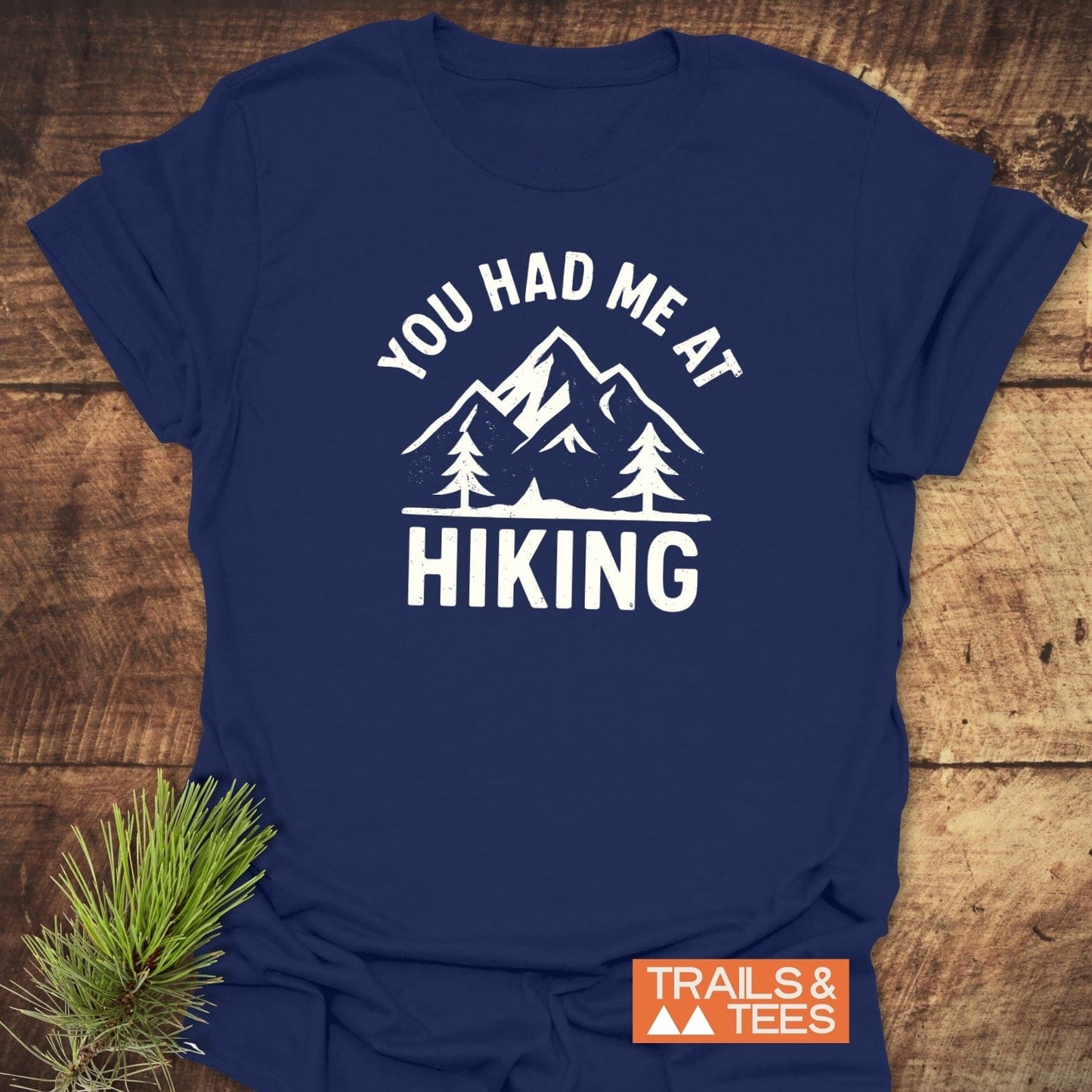 Navy-blue You Had Me At Hiking T-shirt featuring white mountain graphic, crafted from soft cotton, ideal for outdoor enthusiasts, with Trails & Tees logo.