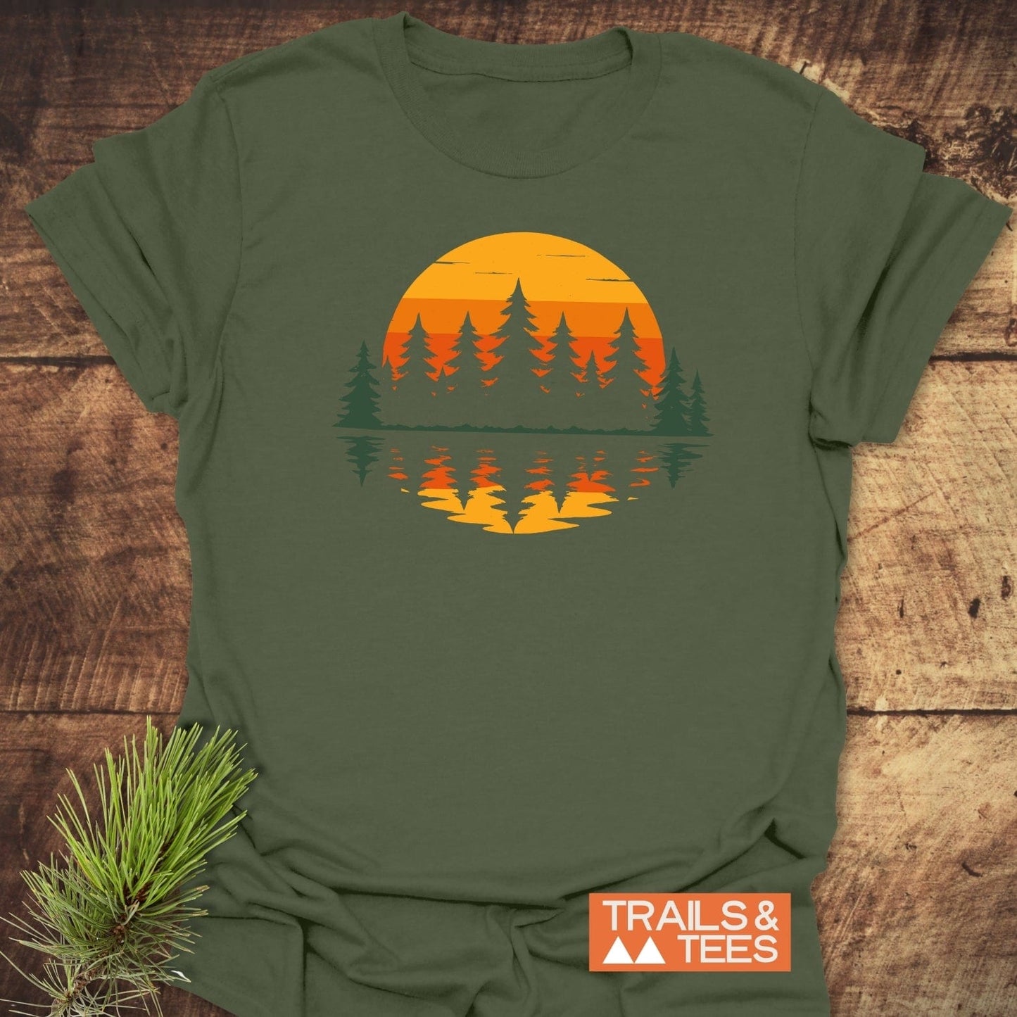 Retro Sunset Pines T-Shirt featuring a stylized sunset and evergreen trees graphic, crafted from soft cotton for comfort. Includes durable prints and sustainable production.