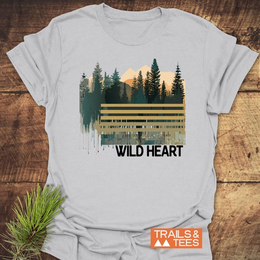 Wild Heart Graphic T-Shirt featuring a stylized outdoor scene with pine trees and mountains, printed on soft, lightweight ring-spun cotton, ideal for everyday adventure.