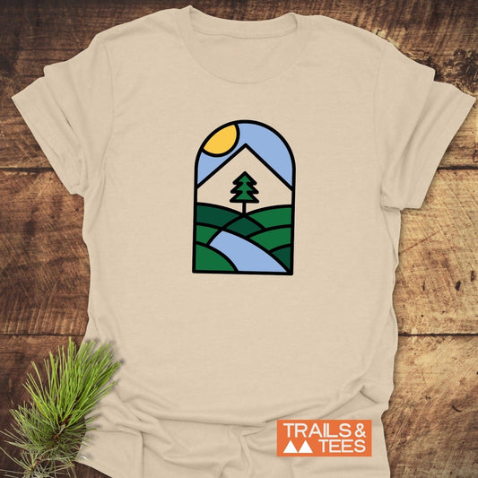 Minimalist Mountain T-Shirt featuring an arched landscape graphic on a beige cotton fabric, showcasing nature’s beauty; perfect for outdoor enthusiasts.