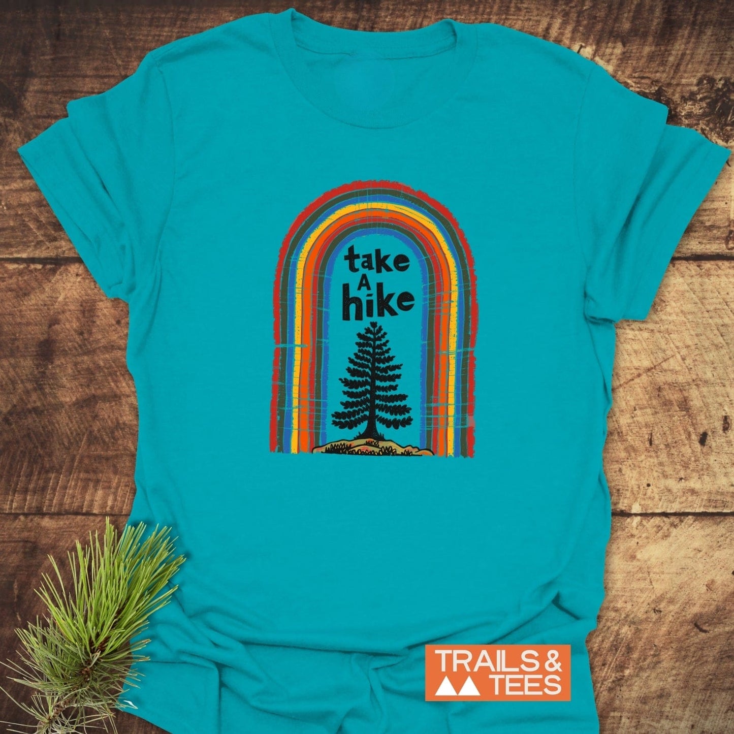 Take A Hike Rainbow T-Shirt with retro arch graphic and pine tree silhouette, crafted from soft cotton for comfort and outdoor adventures.