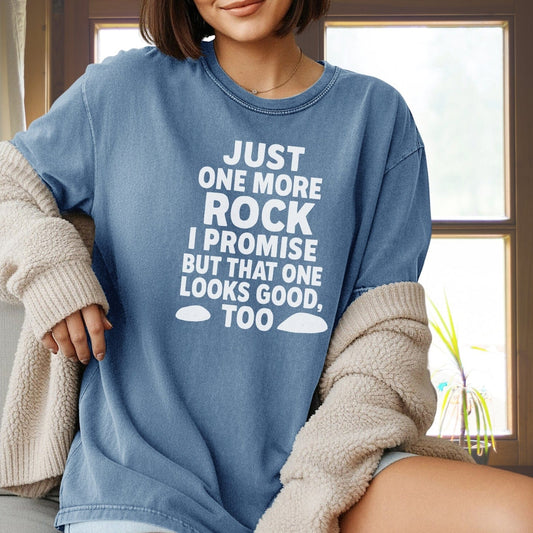Person wearing Just One More Rock Funny Comfort Colors 1717 Tee, a relaxed-fit, durable, garment-dyed shirt, holding a cozy sherpa cardigan indoors.