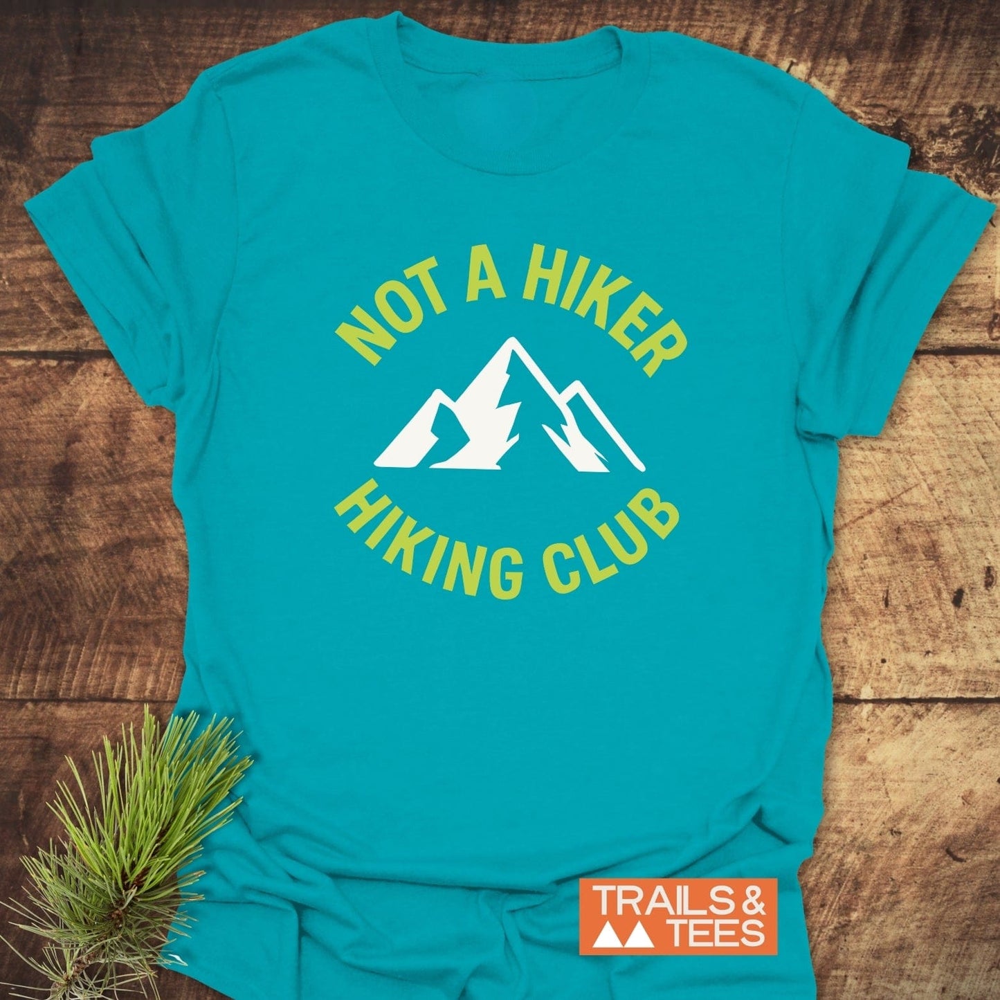 Not A Hiker T-Shirt featuring a mountain graphic and text, crafted from soft ring-spun cotton, designed for comfort and durability, with “TRAILS & TEES” branding.