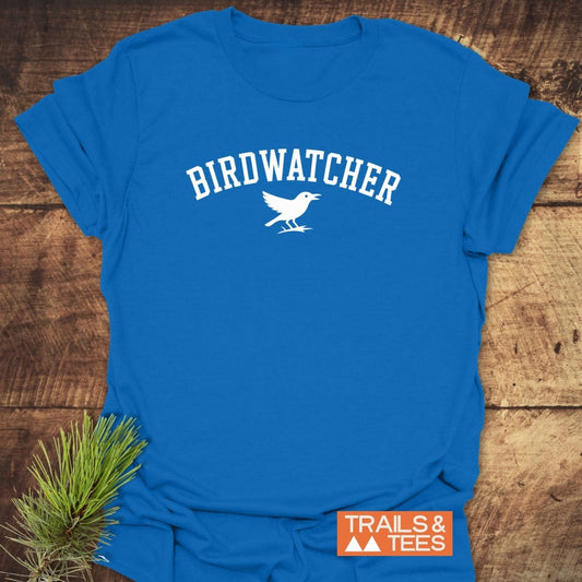 Birdwatcher Varsity T-Shirt, bright blue with BIRDWATCHER and bird design, showcases comfort and durability, ideal for outdoor enthusiasts, featuring Trails & Tees logo.