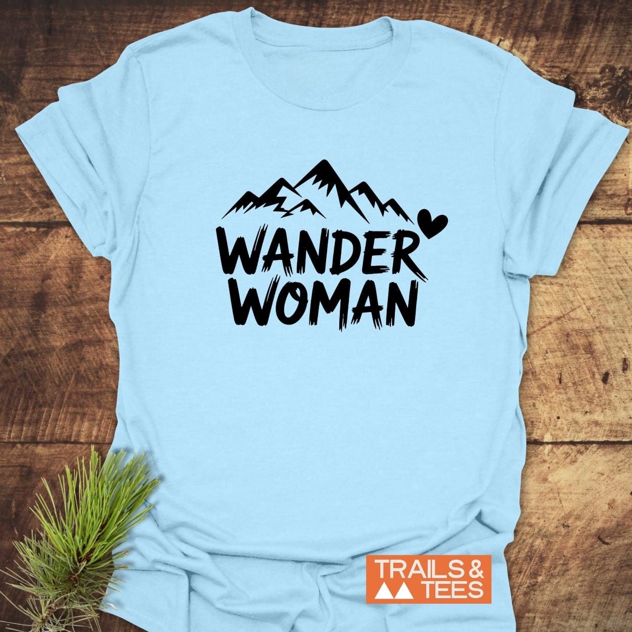 Wander Woman T-Shirt with WANDER WOMAN text and mountain graphic, showcasing comfort in ring-spun cotton, ideal for outdoor enthusiasts.