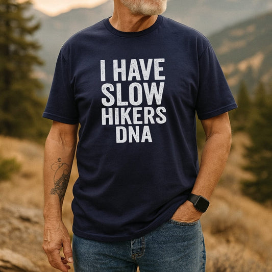 Person outdoors wearing the Slow Hikers DNA T-Shirt, featuring bold white text on navy-blue, paired with blue jeans. Showcasing trail-ready comfort and style, perfect for nature enthusiasts.