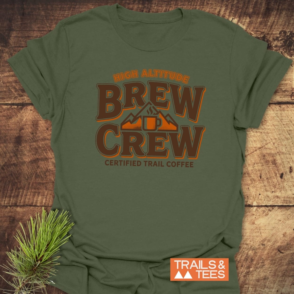Trail Coffee T-Shirt with HIGH ALTITUDE BREW CREW text and coffee mug icon in mountain silhouette. Includes CERTIFIED TRAIL COFFEE slogan and TRAILS & TEES badge, evoking an outdoor adventure theme.