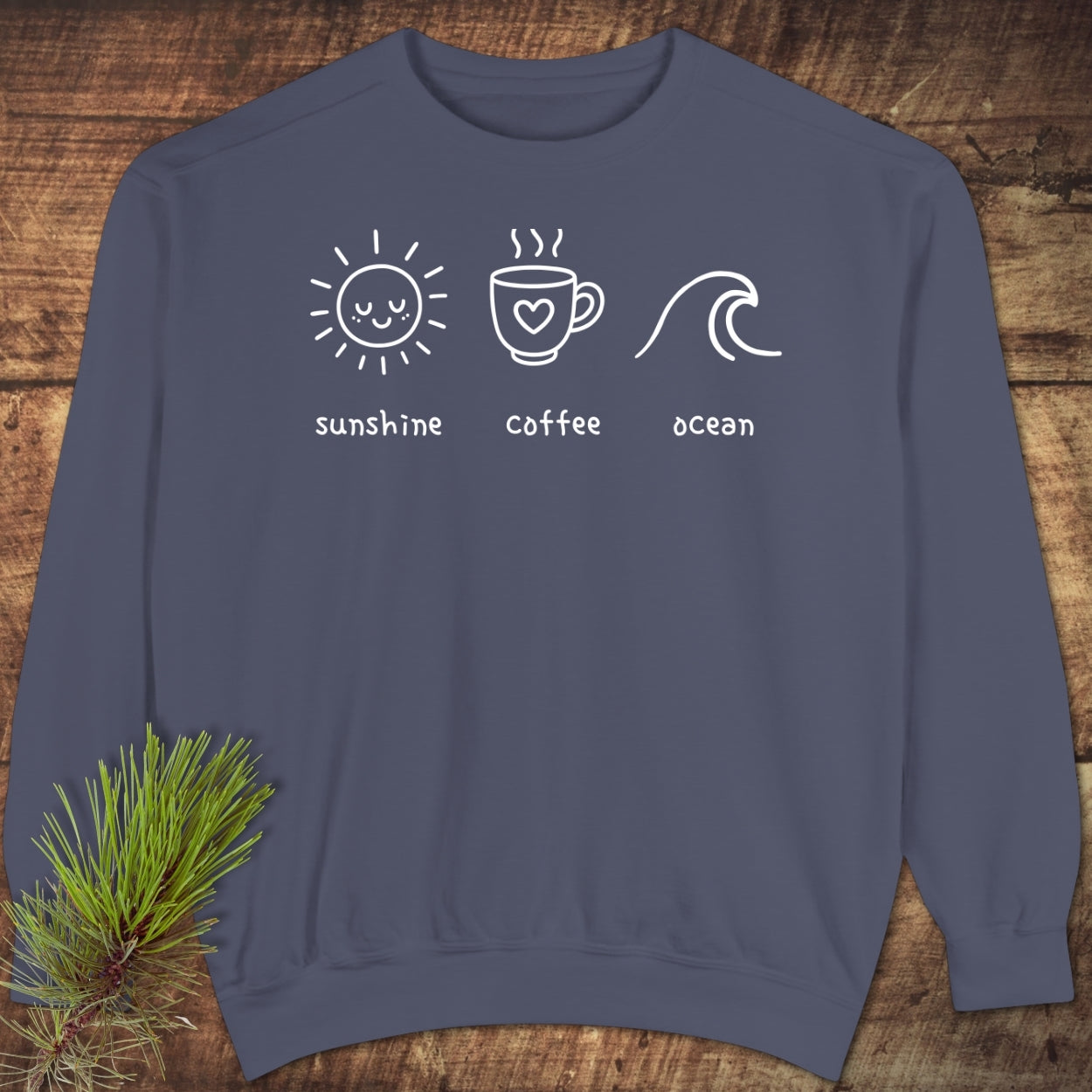I'm A Simple Woman - Sunshine Coffee Ocean Sweatshirt featuring white icons of a sun, coffee mug, and ocean wave on a slate-blue background, highlighting relaxed fit and durable fabric.