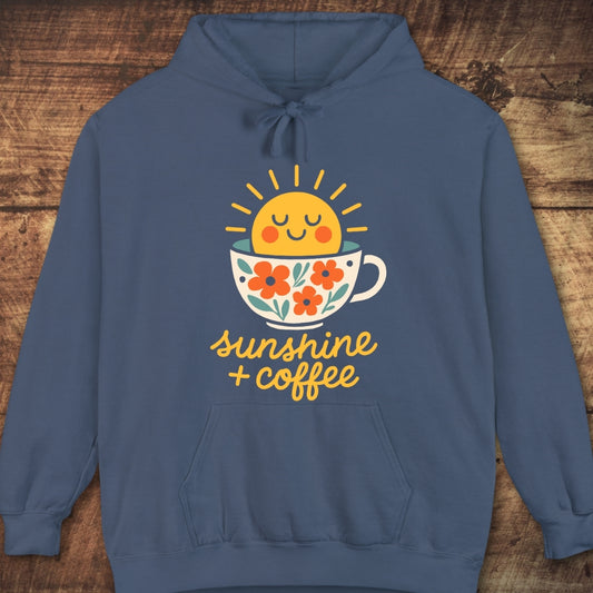 Sunshine And Coffee Hoodie featuring a cheerful sun rising from a floral-decorated coffee cup graphic, capturing trail mornings' comfort with its relaxed fit and soft fleece fabric.