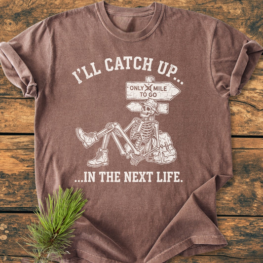 I'll Catch Up - Vintage Wash Tee features a cartoon skeleton in hiking gear against a signpost. The relaxed fit and durable, soft-washed cotton offer comfort and style.
