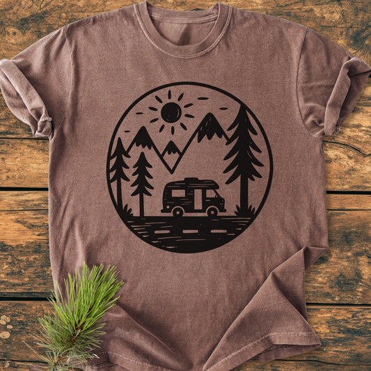 Freedom Is Found Outside - Vintage Wash Tee displayed on wood, features a circular outdoor graphic with sun, mountains, pine trees, and a camper van, highlighting a cozy, garment-dyed, relaxed fit.