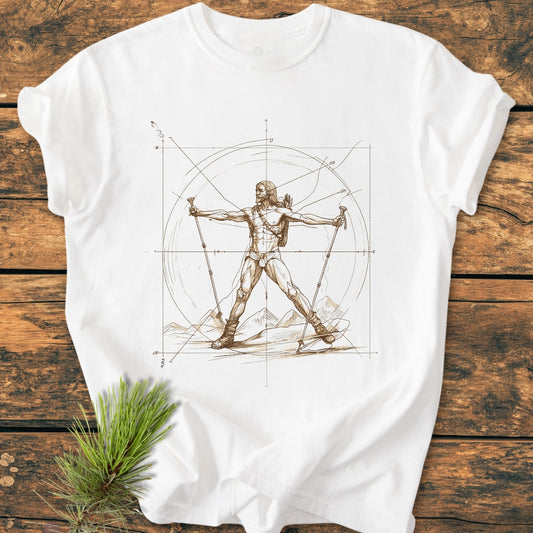 Vitruvian Hiker - Vintage Wash Tee features a sketch-style hiker design on a white T-shirt, laid on a wooden surface with a pine sprig, highlighting its relaxed fit and durable construction.