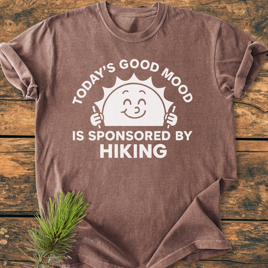 Today's Good Mood - Vintage Wash Tee featuring a smiling sun with hiking poles, printed in white on earth-tone fabric. This relaxed-fit, durable Comfort Colors t-shirt offers a cozy, garment-dyed feel.