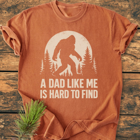 Vintage Bigfoot Dad - Vintage Wash Tee featuring a distressed Bigfoot graphic in front of a full moon and pine trees, with the slogan “A DAD LIKE ME IS HARD TO FIND.”